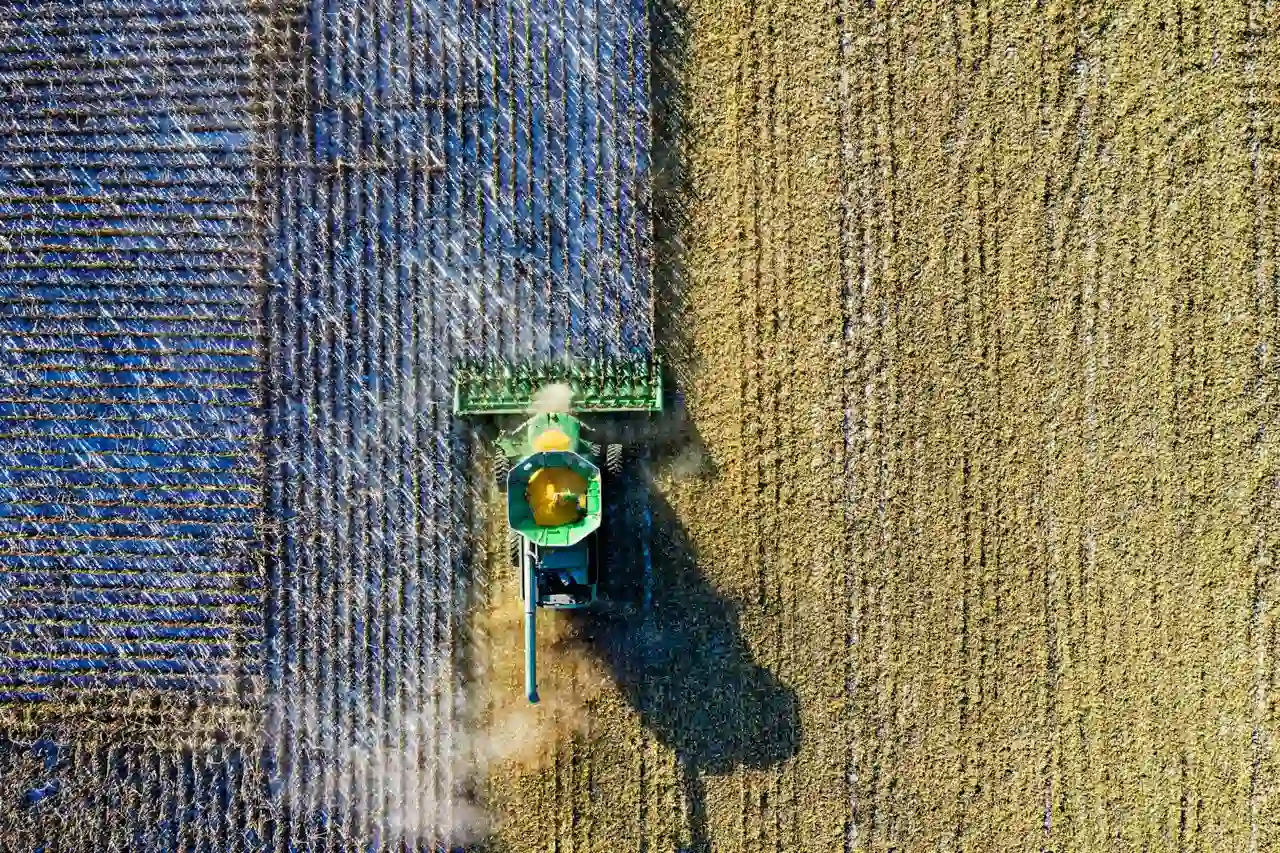 Vista aérea de una cosechadora verde trabajando en un campo de cereales.